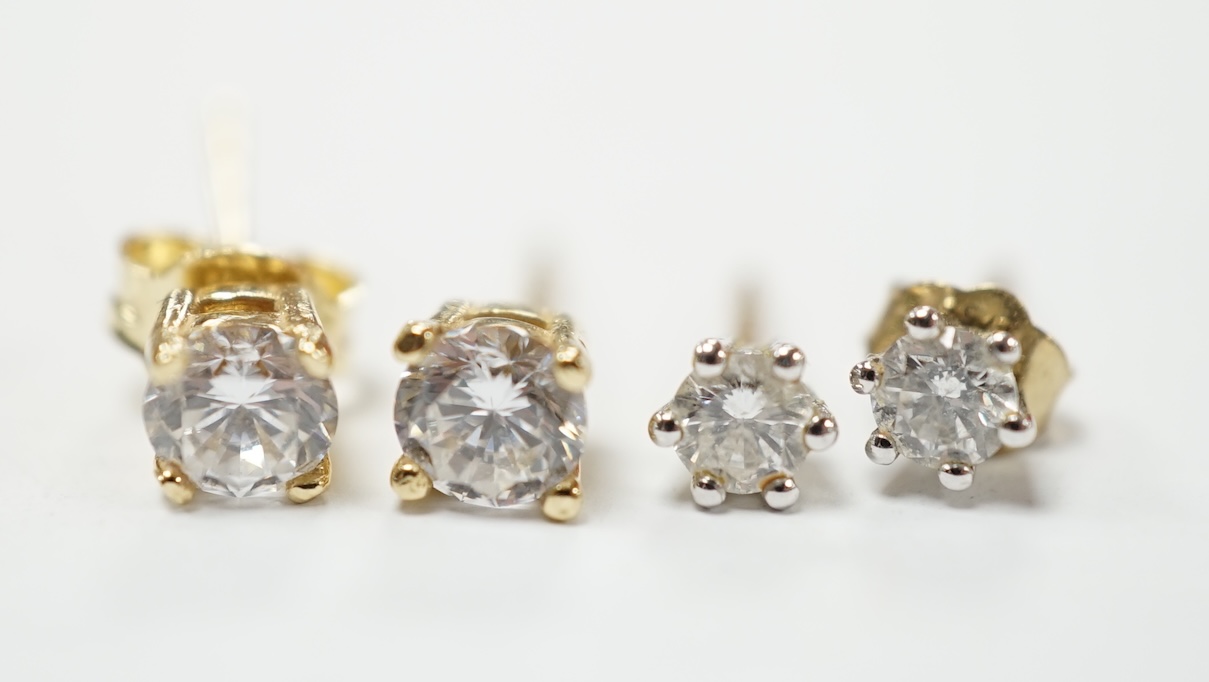 A pair of 585 and solitaire simulated diamond set ear studs and a smaller pair of 375 and solitaire diamond ear studs. Good condition.